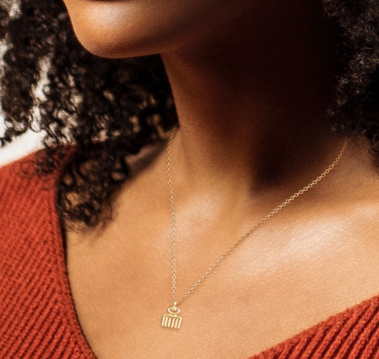 Adinkra Collection Duafe Necklace in polished 14ct yellow gold with 10mm pendant. Symbolizes beauty, femininity, love, and care. Versatile for everyday wear, perfect alone or layered. Sold on a 16-inch chain.