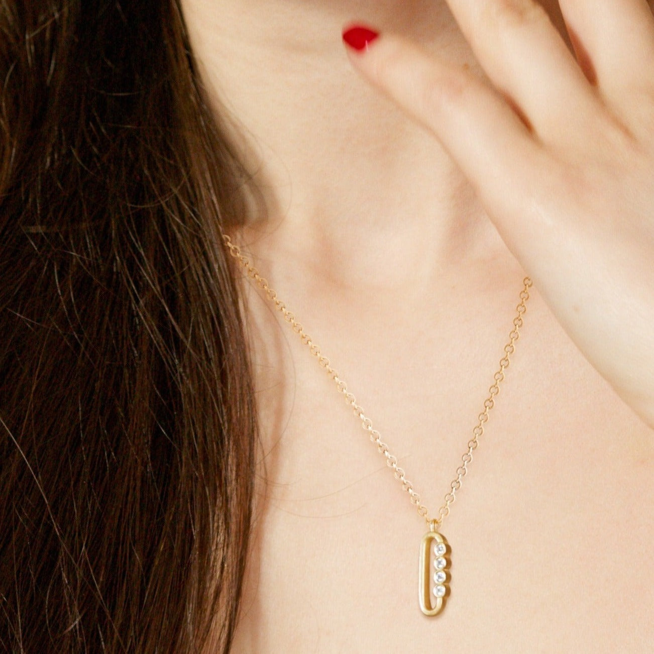 Legacy Collection Nina Pendant in polished 18ct yellow gold with 0.16ct VS/SI diamonds, 15mm length. A refined tribute to an icon, perfect for a subtle yet striking statement. Worn alone or layered. Sold on an 18-inch chain, customizable with alternative gemstones.