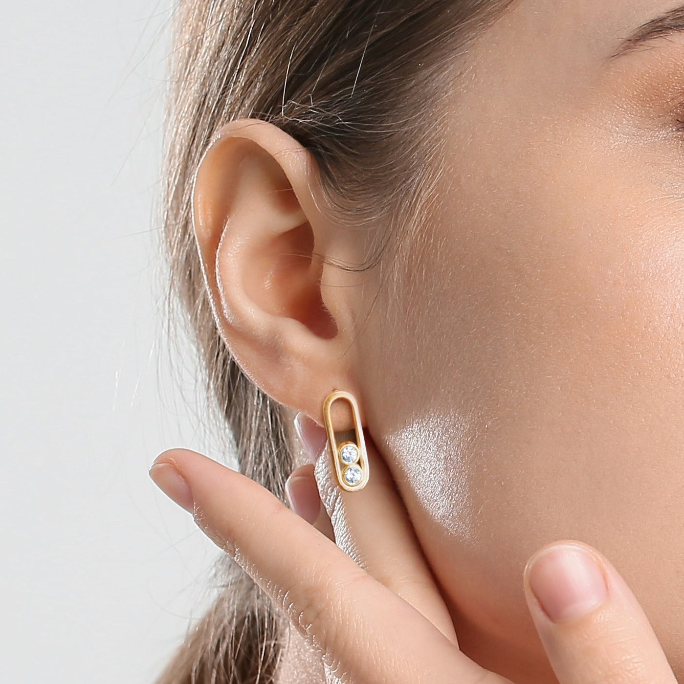 Model wearing Anita Earrings in 14ct yellow gold with 0.5ct SI1 diamonds, 10mm length. Classic glamour, versatile for daily wear or special events. Customizable with alternative gemstones. Sold as a pair on white background